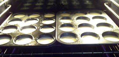 Two muffin tins in the oven filled batter.