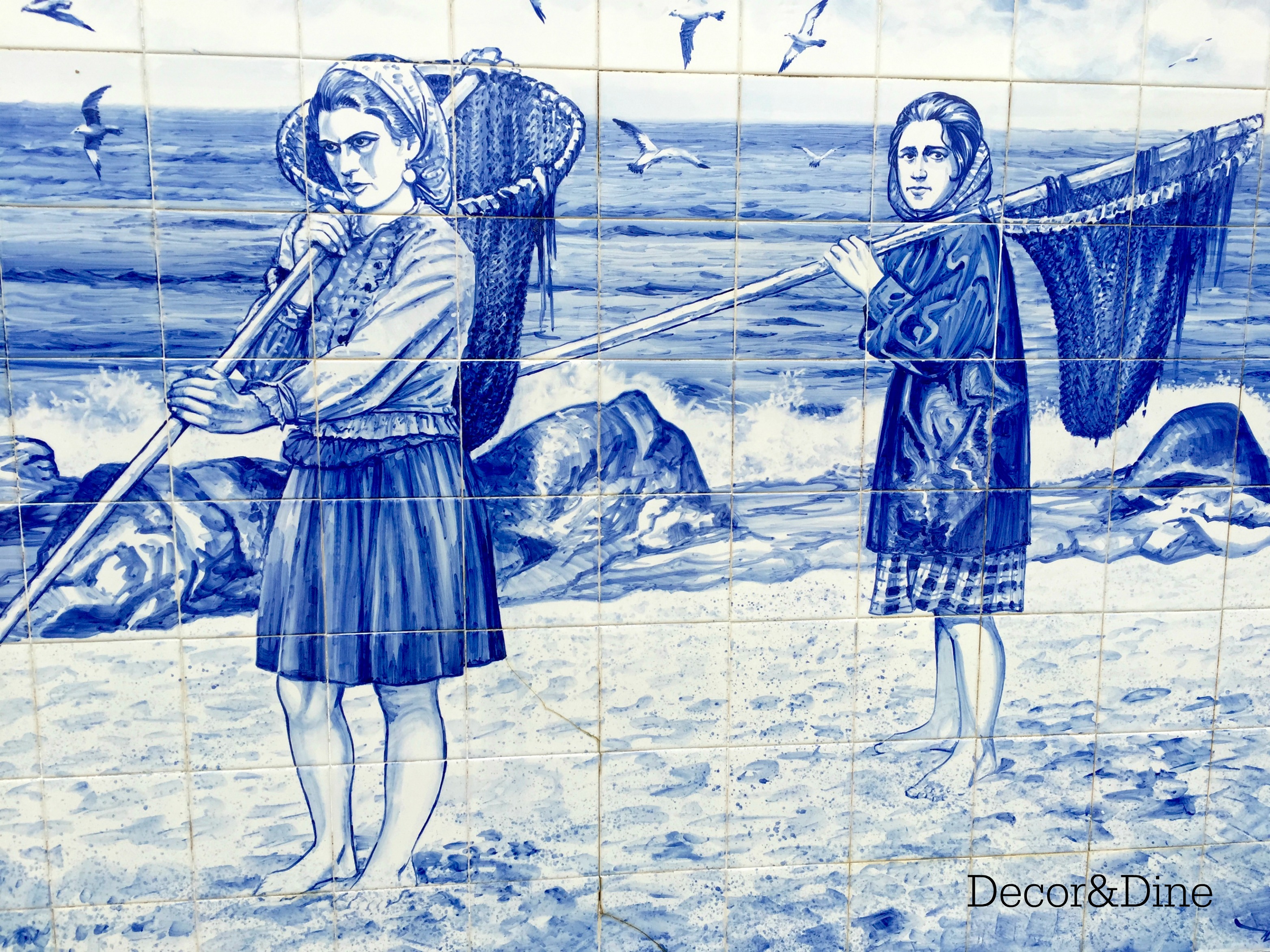 Azulejo, Povoa de Varzim. Two women holding fishing nets on a beach.