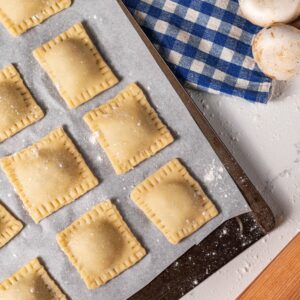 Raviolis on a baking tray.