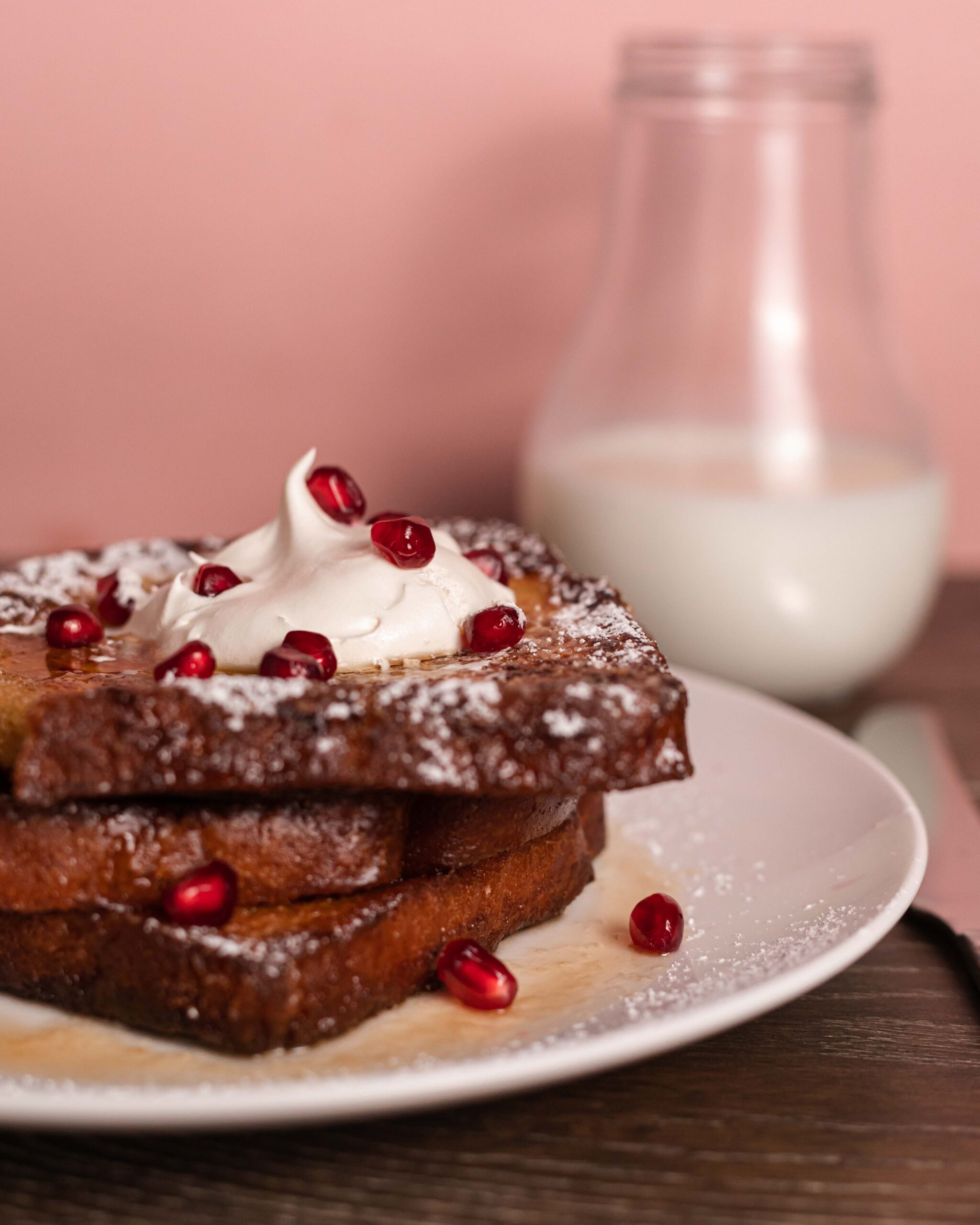 French toast topped with whipped cream and pomegranate seeds.