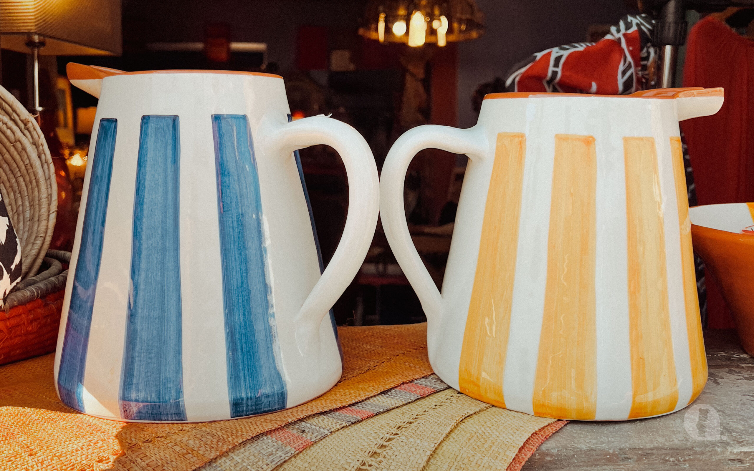 White and blue ceramic jug on left. White and yellow ceramic jug on right.