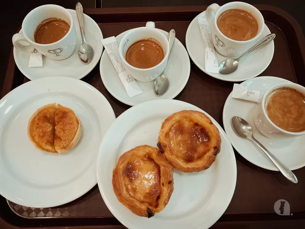 four espressos with two pasteis de natas