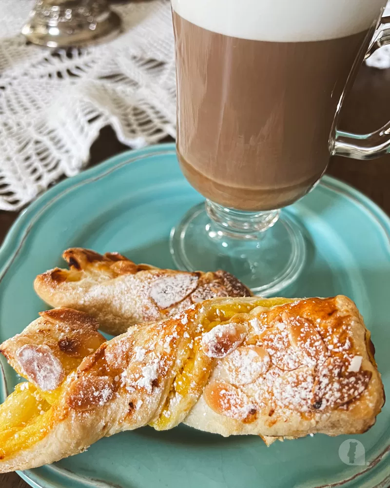 An almond twist pastry with a latté